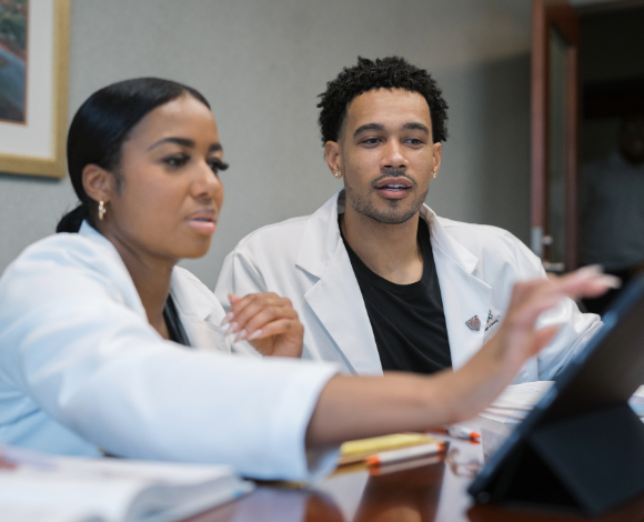 a male student and female student looking at a tablet together