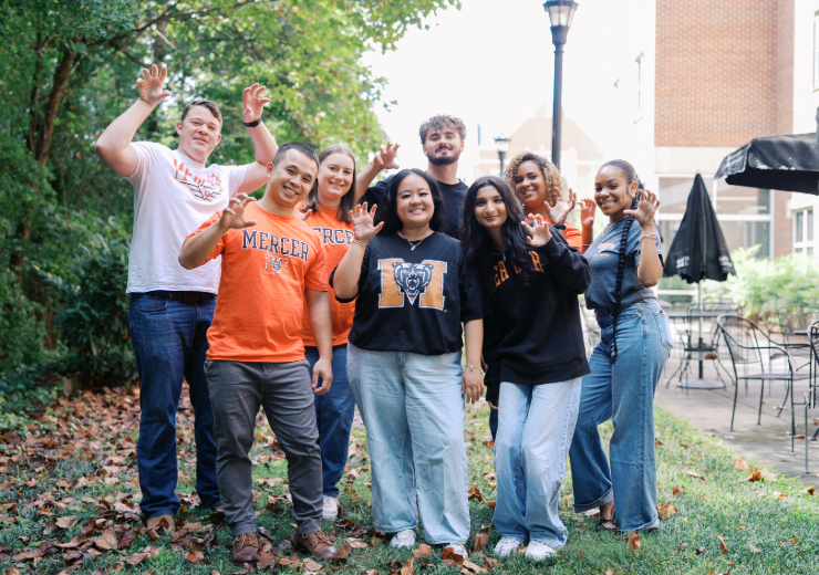 group of nursing students smiling at the camera while holding up their hands in a bear claw shape