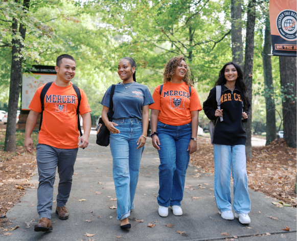 four students walking and smiling together