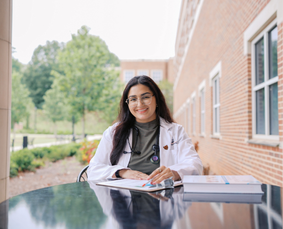 female graduate nursing student with textbooks in front of her